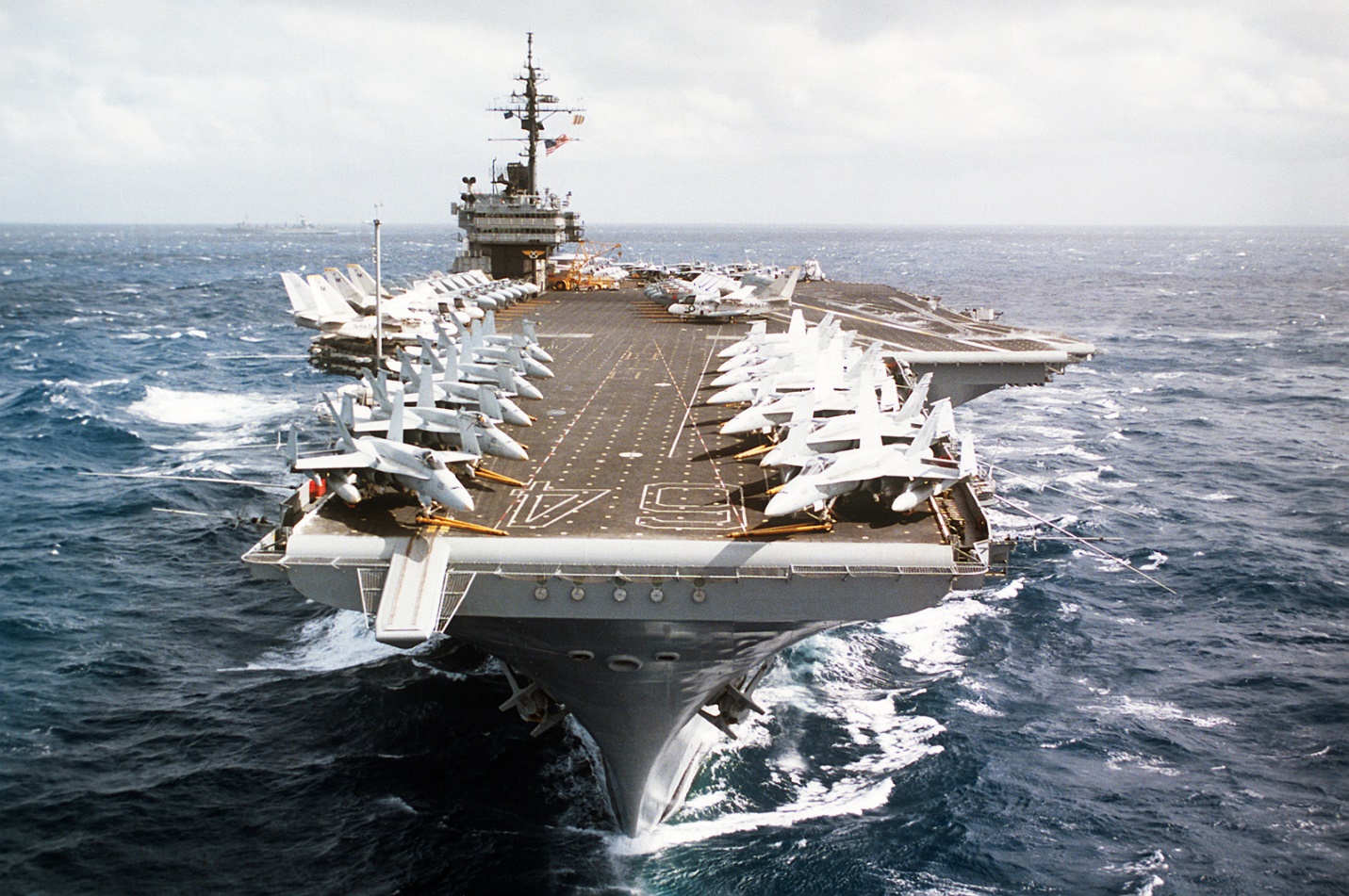 A bow view of the aircraft carrier USS CONSTELLATION (CV-64) underway. Various aircraft of the carrier&#39;s air wing are parked on the flight deck - U.S. National Archives &amp; DVIDS Public Domain